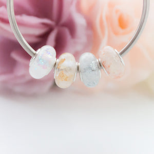 RubyBabyDesigns Keepsake Collective Breastfeeding Milestone European Bead Charms, created with resin and pearl pigment, foil flakes and opal flakes. Handmade in Melbourne. Afterpay available.