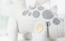 Load image into Gallery viewer, RubyBabyDesigns Keepsake Collective Heirloom Cloth Duke the Dinosaur Keepsake decor. White base with grey etched print, with co-ordinating grey felt spots, and silver faux leather dinosaur spines. Bought to life using environmentally friendly PET fill and wooden buttons on his legs. Designed and handmade in Melbourne.