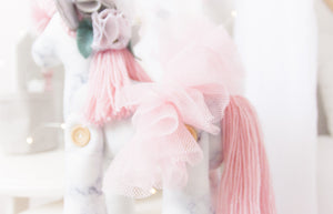 RubyBabyDesigns Keepsake Collective Heirloom Deluxe Unity the Unicorn Ballerina is a lovely soft grey and white marble digital print. Paired with a soft blush wool mane and tail, along with tulle ballerina skirt. She also has shabby flowers set within her mane and silver faux leather ears and horn. Handmade engraved wooden buttons on the legs, and filled with PET environmentally friendly fill, handmade and designed in Melbourne.