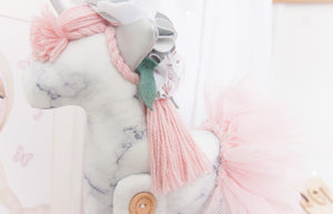RubyBabyDesigns Keepsake Collective Heirloom Deluxe Unity the Unicorn Ballerina is a lovely soft grey and white marble digital print. Paired with a soft blush wool mane and tail, along with tulle ballerina skirt. She also has shabby flowers set within her mane and silver faux leather ears and horn. Handmade engraved wooden buttons on the legs, and filled with PET environmentally friendly fill, handmade and designed in Melbourne.